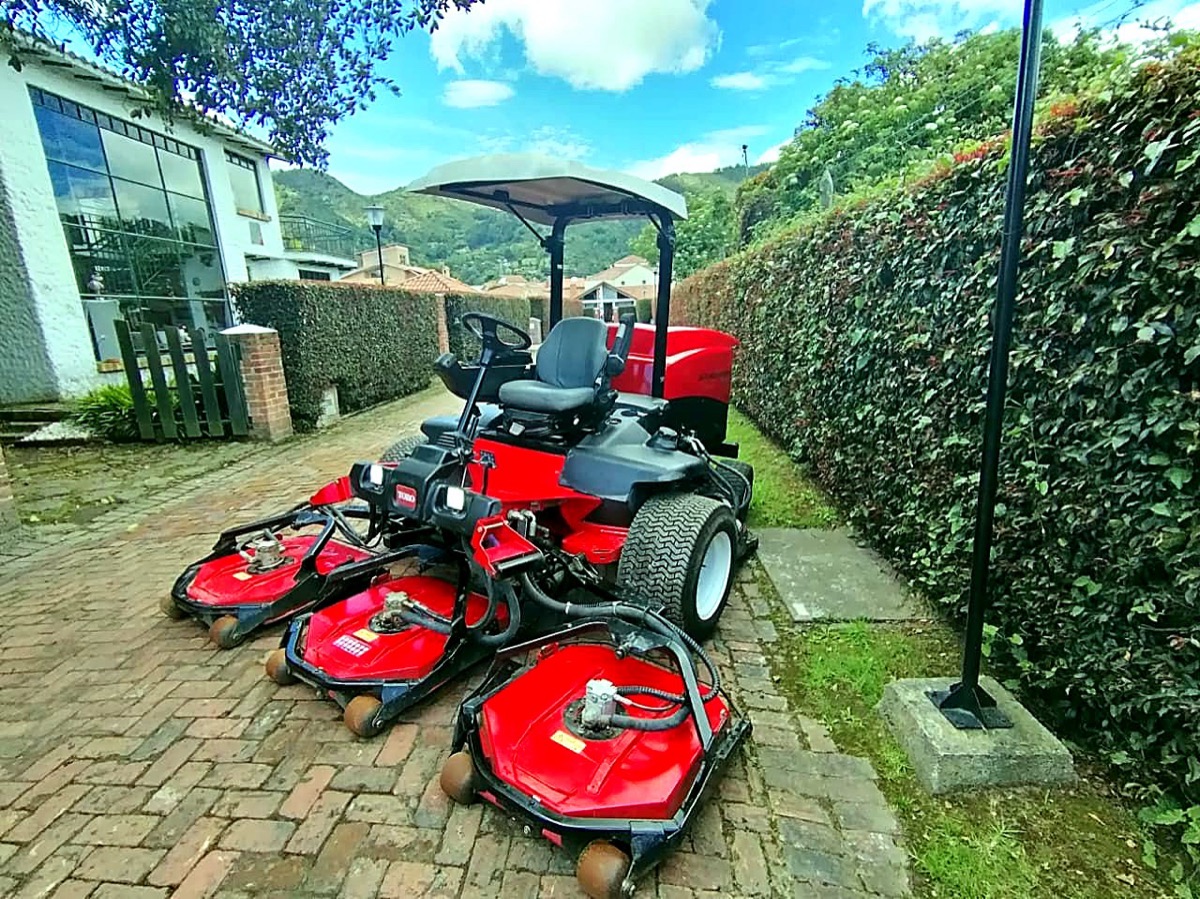 Cortadora Toro Groundsmaster con múltiples unidades de corte junto a un seto
